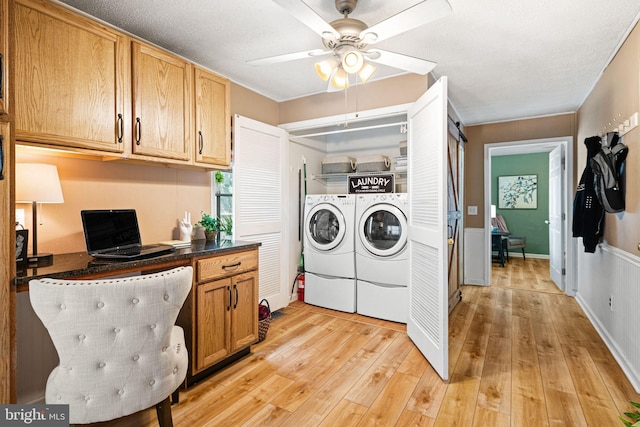 laundry room featuring ceiling fan, washing machine and dryer, light hardwood / wood-style floors, and a textured ceiling