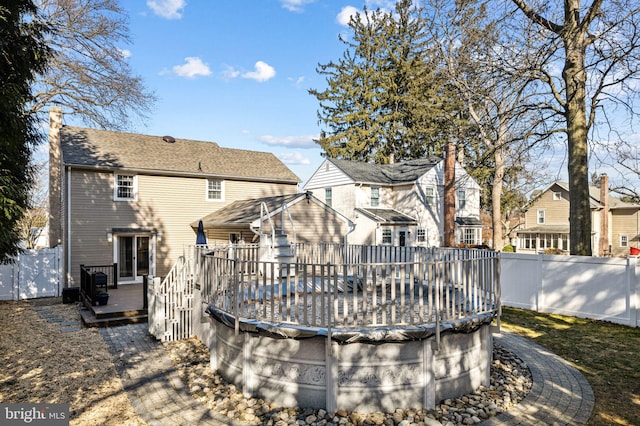 back of house featuring a pool side deck