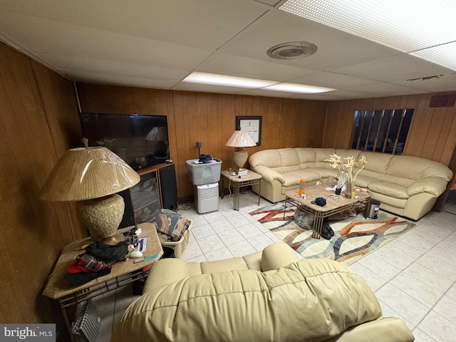 living room with a drop ceiling and wood walls