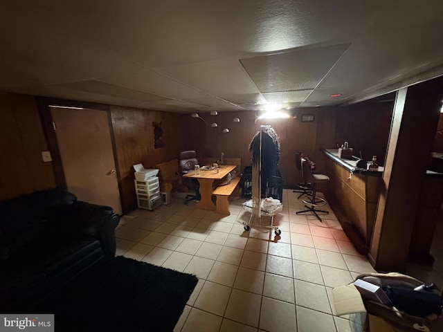 basement with light tile patterned floors and wood walls