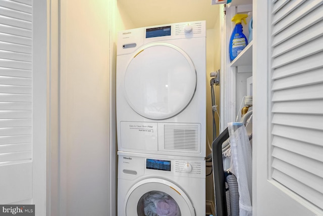 clothes washing area with stacked washer and dryer