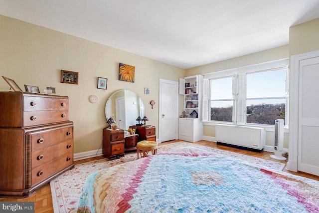 bedroom with radiator and light parquet floors