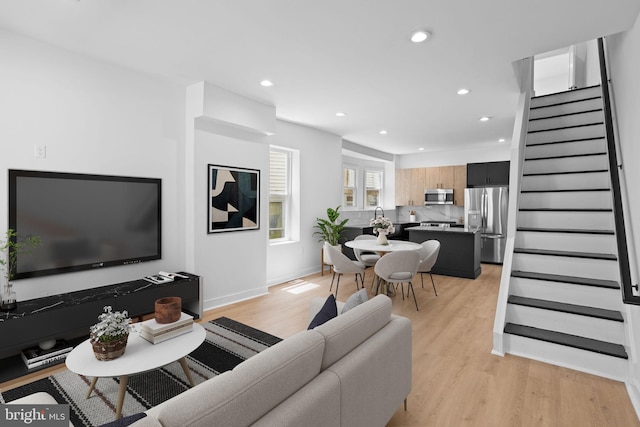 living room featuring light wood-type flooring and sink