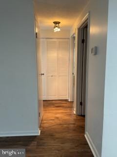 corridor with dark hardwood / wood-style flooring