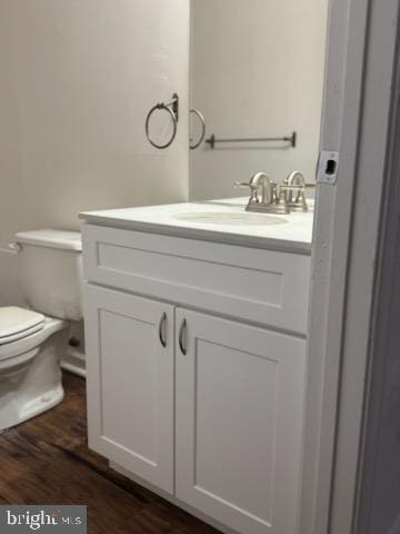 bathroom with hardwood / wood-style flooring, vanity, and toilet