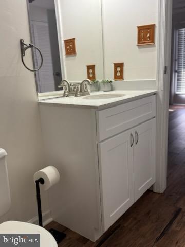 bathroom featuring vanity, wood-type flooring, and toilet