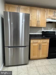 kitchen with stainless steel fridge, light tile patterned floors, light brown cabinets, and electric range