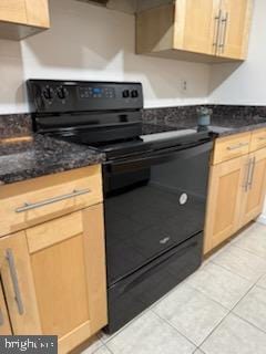 kitchen with black range with electric stovetop, dark stone countertops, light tile patterned floors, and light brown cabinets