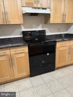 kitchen featuring dark stone counters, black electric range oven, and light tile patterned floors