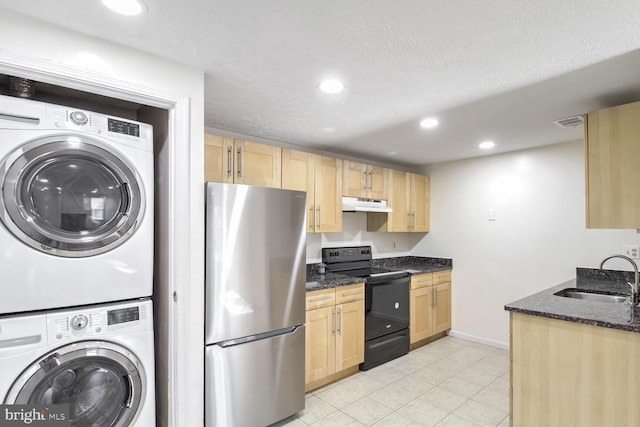 kitchen with stacked washer / drying machine, sink, black electric range, stainless steel refrigerator, and dark stone counters