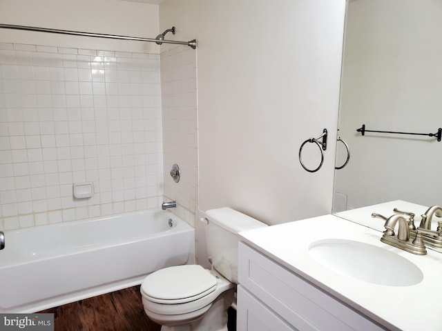 full bathroom featuring vanity, toilet, tiled shower / bath combo, and hardwood / wood-style floors