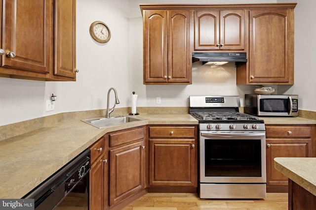 kitchen with ventilation hood, stainless steel appliances, light hardwood / wood-style floors, and sink