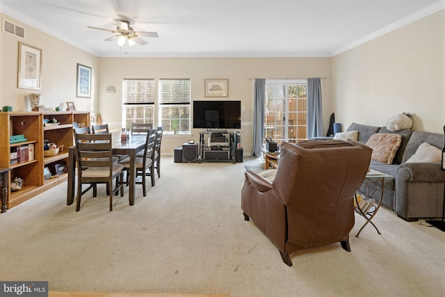 living room with ceiling fan, light colored carpet, and ornamental molding