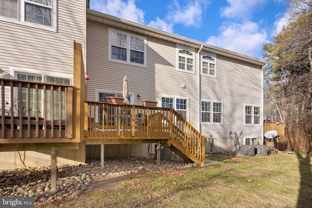 rear view of property featuring a wooden deck and a yard