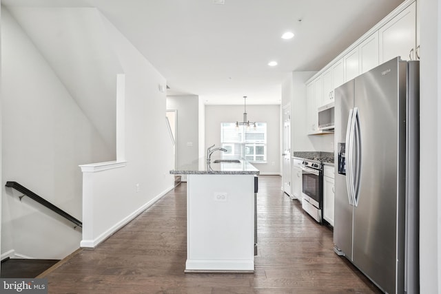 kitchen featuring stone countertops, white cabinetry, an island with sink, hanging light fixtures, and stainless steel appliances