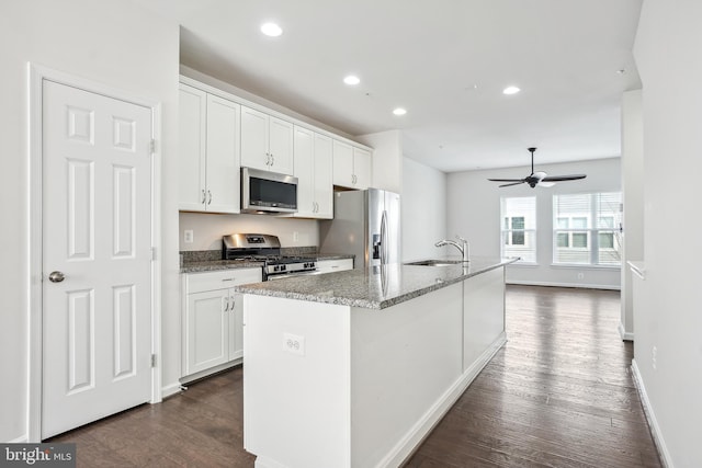 kitchen with a kitchen island with sink, sink, white cabinetry, and appliances with stainless steel finishes