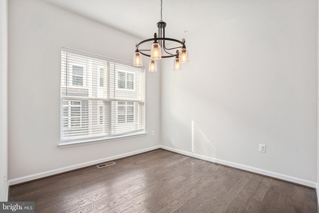 unfurnished dining area with dark hardwood / wood-style flooring and a chandelier