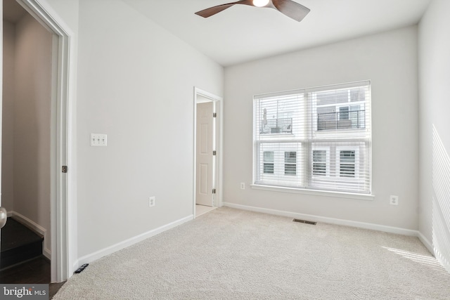 carpeted spare room with ceiling fan