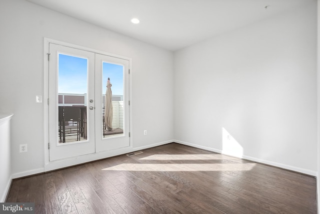 empty room featuring french doors and dark hardwood / wood-style floors