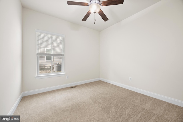 carpeted empty room with baseboards, visible vents, and ceiling fan