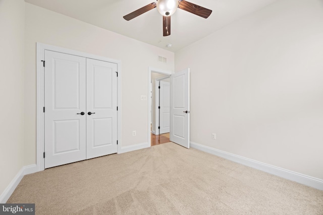 unfurnished bedroom featuring carpet floors, a ceiling fan, visible vents, baseboards, and a closet