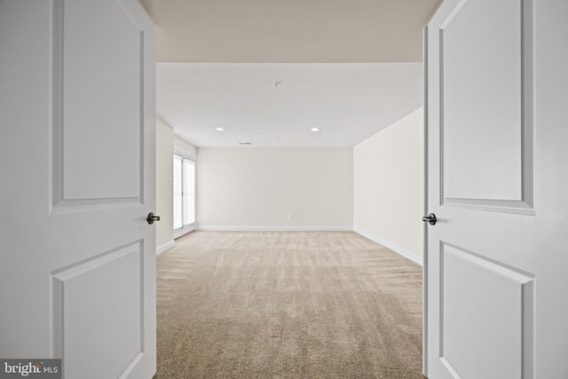 unfurnished room featuring recessed lighting, light colored carpet, and baseboards