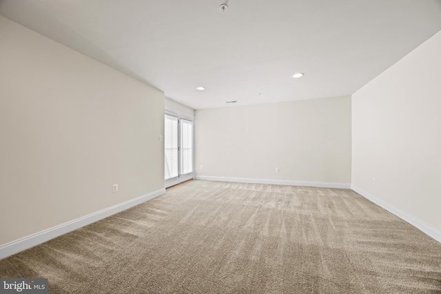 unfurnished room with light carpet, recessed lighting, and baseboards