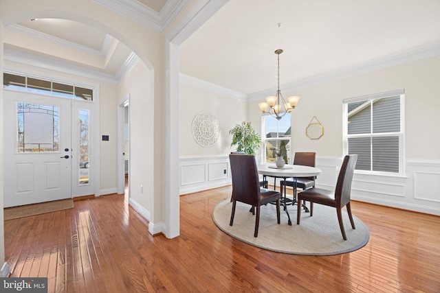 dining room featuring an inviting chandelier, ornamental molding, and hardwood / wood-style floors