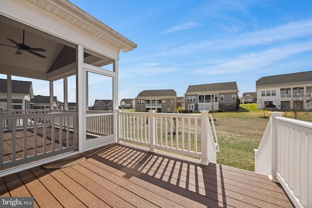 deck with a residential view, a sunroom, and ceiling fan