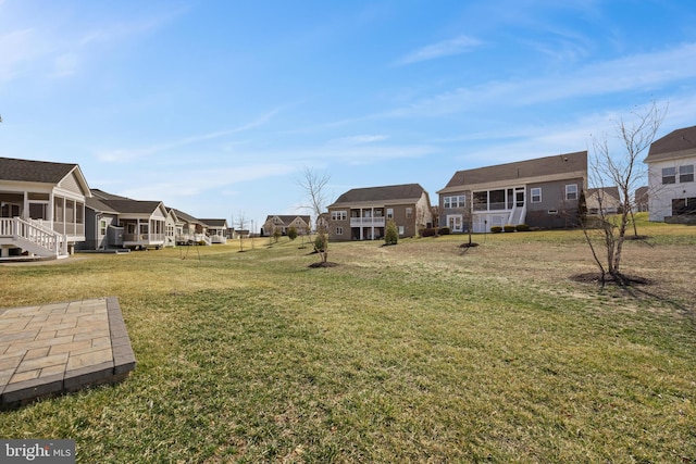 view of yard with a sunroom and a residential view