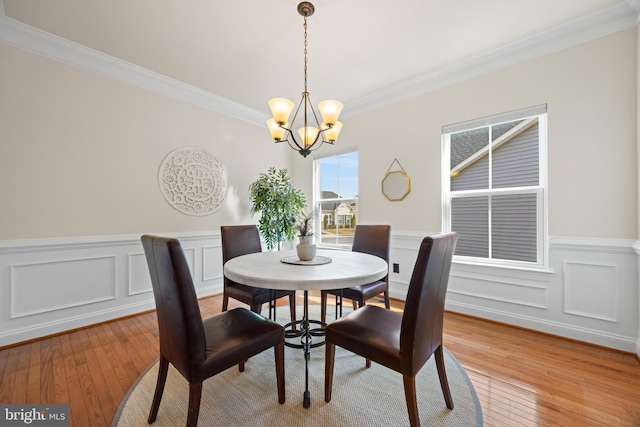 dining space featuring a chandelier, crown molding, and light wood finished floors