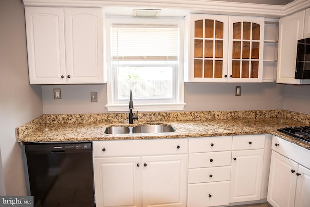 kitchen with black appliances, light stone countertops, sink, and white cabinetry