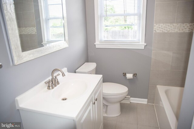 bathroom with toilet, vanity, tile patterned floors, and a wealth of natural light