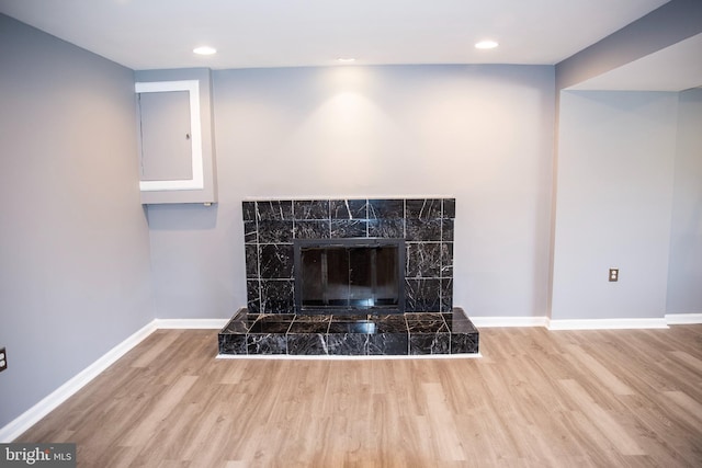 room details with a tile fireplace and hardwood / wood-style floors