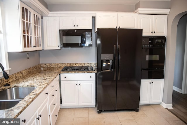 kitchen featuring black appliances, white cabinets, light stone countertops, and sink