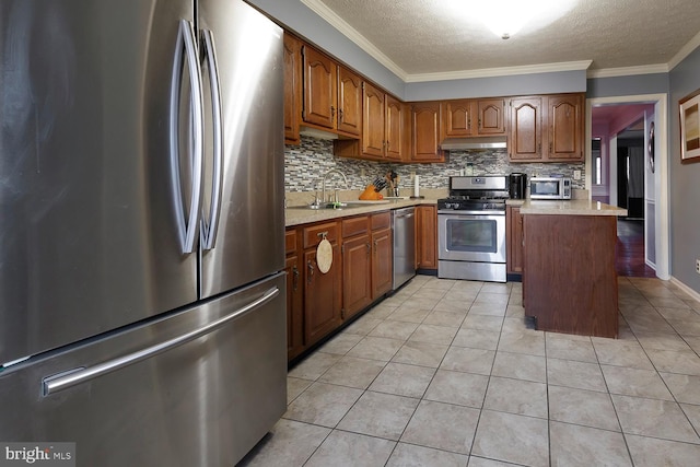 kitchen featuring light tile patterned floors, appliances with stainless steel finishes, decorative backsplash, crown molding, and sink