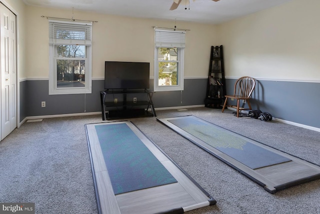 workout room featuring ceiling fan and carpet