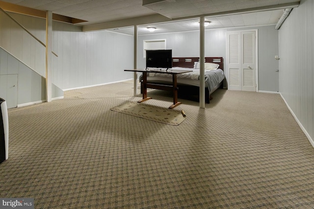 bedroom featuring carpet floors and wooden walls