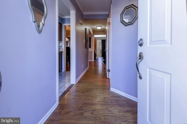 hallway featuring a textured ceiling, dark hardwood / wood-style floors, and crown molding