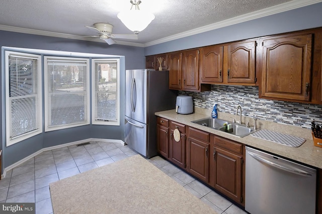 kitchen featuring sink, appliances with stainless steel finishes, ornamental molding, and light tile patterned flooring