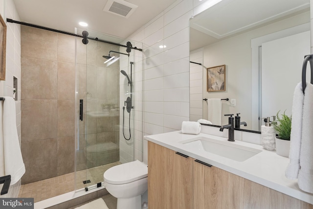 bathroom featuring toilet, a shower with door, and vanity