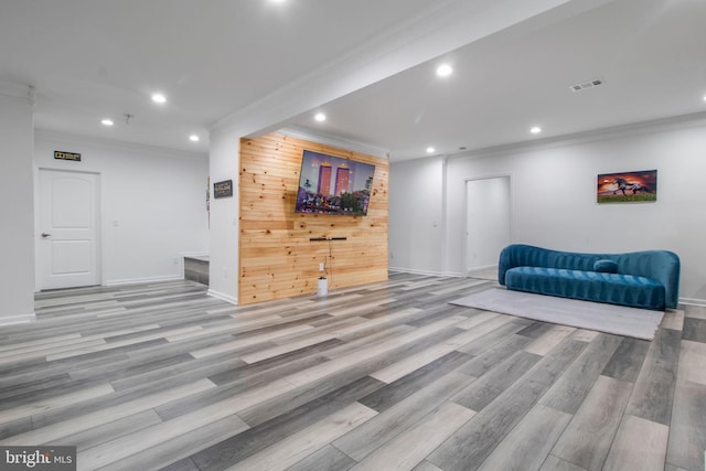 sitting room with ornamental molding and light wood-type flooring