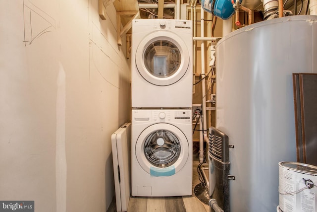 clothes washing area with stacked washing maching and dryer