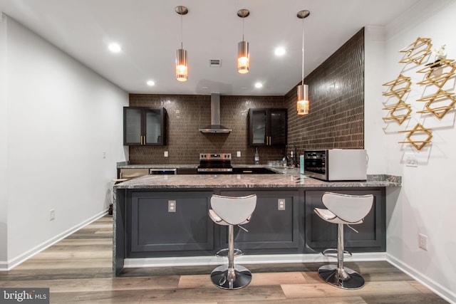 bar featuring wall chimney exhaust hood, sink, wood-type flooring, appliances with stainless steel finishes, and backsplash