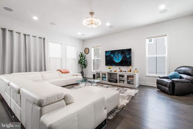 living room with dark wood-type flooring and a notable chandelier