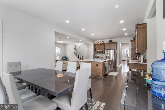 dining space with dark hardwood / wood-style flooring, sink, and plenty of natural light