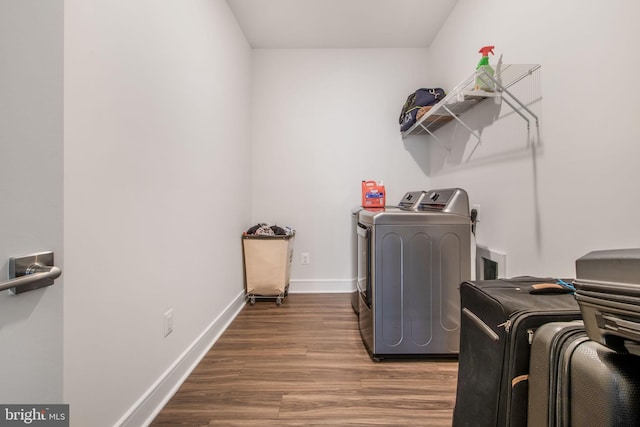 washroom with dark hardwood / wood-style floors and washing machine and dryer