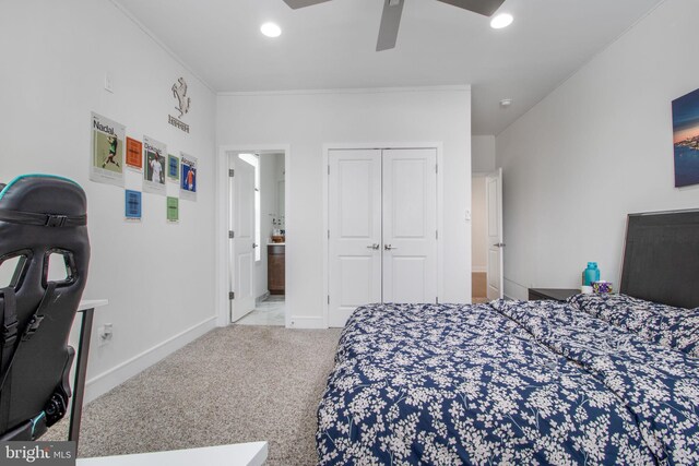 carpeted bedroom with a closet, ceiling fan, and ensuite bathroom