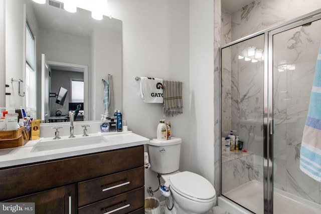 bathroom featuring vanity, toilet, and an enclosed shower