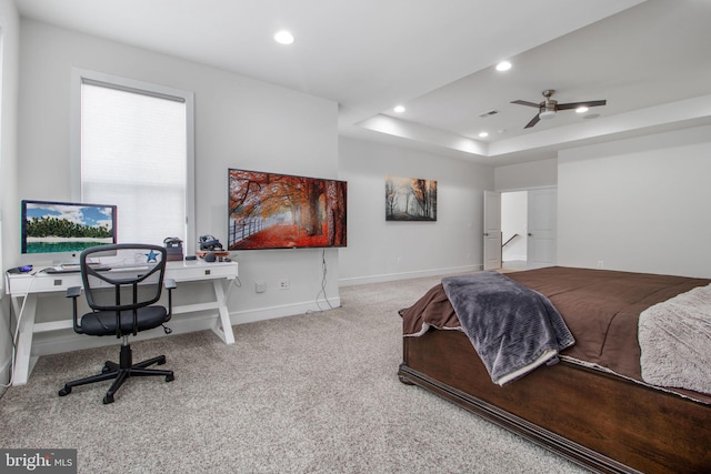 bedroom featuring a raised ceiling and light carpet